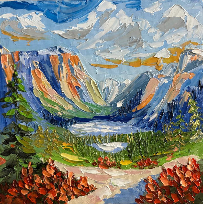 May include: Square oil painting of a mountain landscape with a lake. The artwork features textured brushstrokes in shades of blue, orange, green, and white. The sky is a light blue with white clouds, and the foreground shows a path and red flowers.