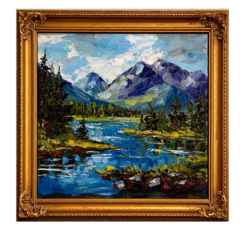 May include: Oil painting of a mountain landscape with a lake, framed in a gold ornate frame. The artwork features a blue lake, green trees, and purple mountains under a blue sky with white clouds.