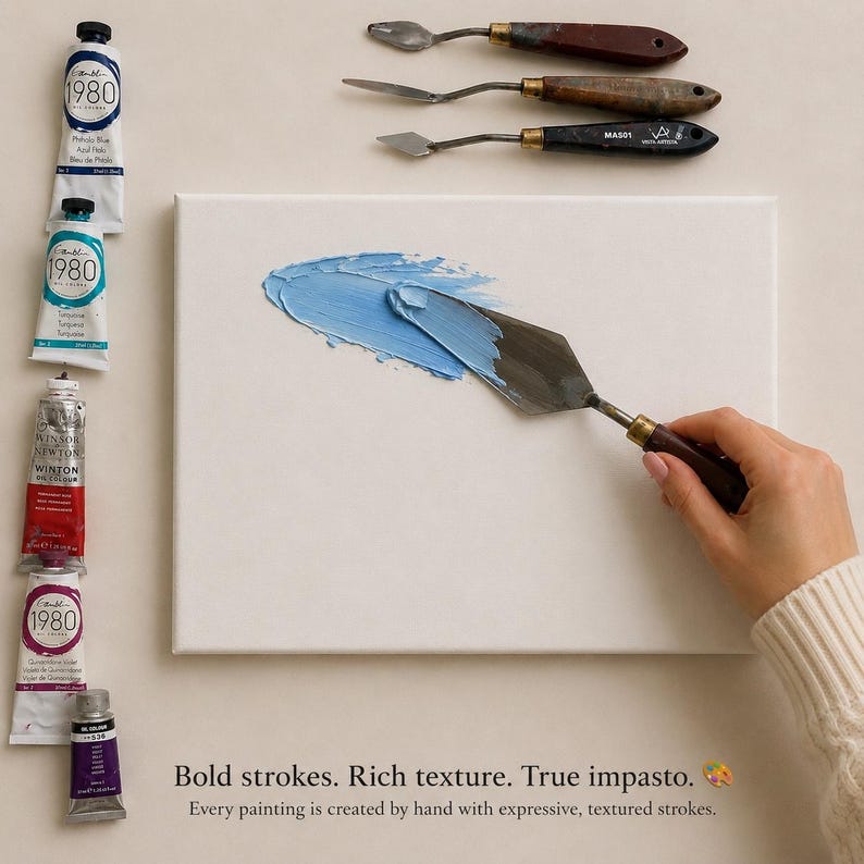 May include: A white rectangular canvas with a smear of light blue oil paint applied by a metal palette knife. Five tubes of oil paint in various colors are arranged vertically on the left, with three additional palette knives above the canvas.