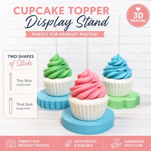 Op de afbeelding: Een 3D-geprinte cupcake topper displaystandaard set met drie ronde voetstukken in blauw, groen en roze. Elke voet houdt een wit cupcake-model met groene, roze of blauwe glazuur. Tekst bevat CUPCAKE TOPPER DISPLAY STAND en TWO SHAPES of Sticks.
