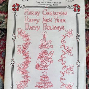 May include: A white paper with red Christmas-themed illustrations and text. The text reads "Merry Christmas, Happy New Year, Happy Holidays." The design includes Santa Claus, a Christmas tree, and decorative borders.