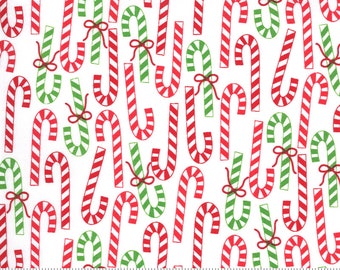 Könnte beinhalten: Weißer Stoff mit einem sich wiederholenden Muster aus roten und grünen Zuckerstangen. Die Zuckerstangen sind gestreift und haben oben eine Schleife.