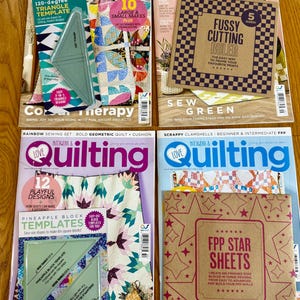 May include: Four issues of "Love Patchwork & Quilting" magazine are displayed, each with a different cover. The magazines feature quilting templates and patterns, including a 120-degree triangle template and a fussy cutting ruler. The covers are colorful and feature various quilt designs.