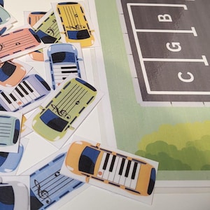 May include: A selection of car-shaped stickers featuring piano key designs and musical notation. The stickers are in shades of yellow, blue, and pink. A parking game board is in the background.
