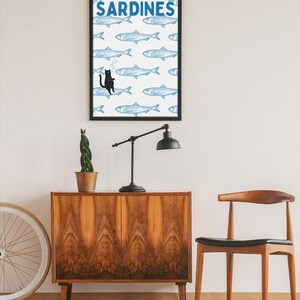 Featuring a retro-inspired blue sardine pattern on a crisp white background, this design stands out with a playful black cat floating among the fish, blowing bubbles. A perfect mix of vintage charm and quirky humor.