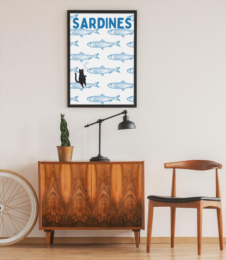 Featuring a retro-inspired blue sardine pattern on a crisp white background, this design stands out with a playful black cat floating among the fish, blowing bubbles. A perfect mix of vintage charm and quirky humor.