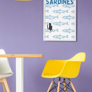 Featuring a retro-inspired blue sardine pattern on a crisp white background, this design stands out with a playful black cat floating among the fish, blowing bubbles. A perfect mix of vintage charm and quirky humor.