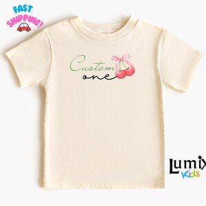 カスタムチェリーTシャツ、チェリーのかわいいワンジー、かわいいシャツ、リボンベビー、リボンシャツ、パーソナライズされた名前、ベビーチェリーの衣装