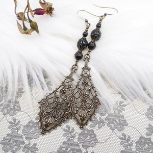 gorgeous large antique brass filigree pendants are accented by me with top quality black pearls.