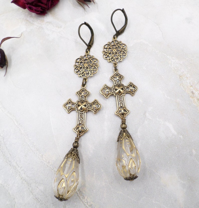 unique acrylic beads in clear with gold wash are wired by me to ornate filigree brass cross connectors and filigree rounds in these long handmade earrings.