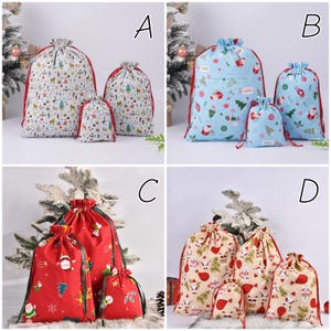 May include: Set of three Christmas-themed drawstring gift bags. The bags feature various festive patterns, including reindeer, trees, and Santa Claus. Each bag has a red drawstring closure and comes in different sizes.