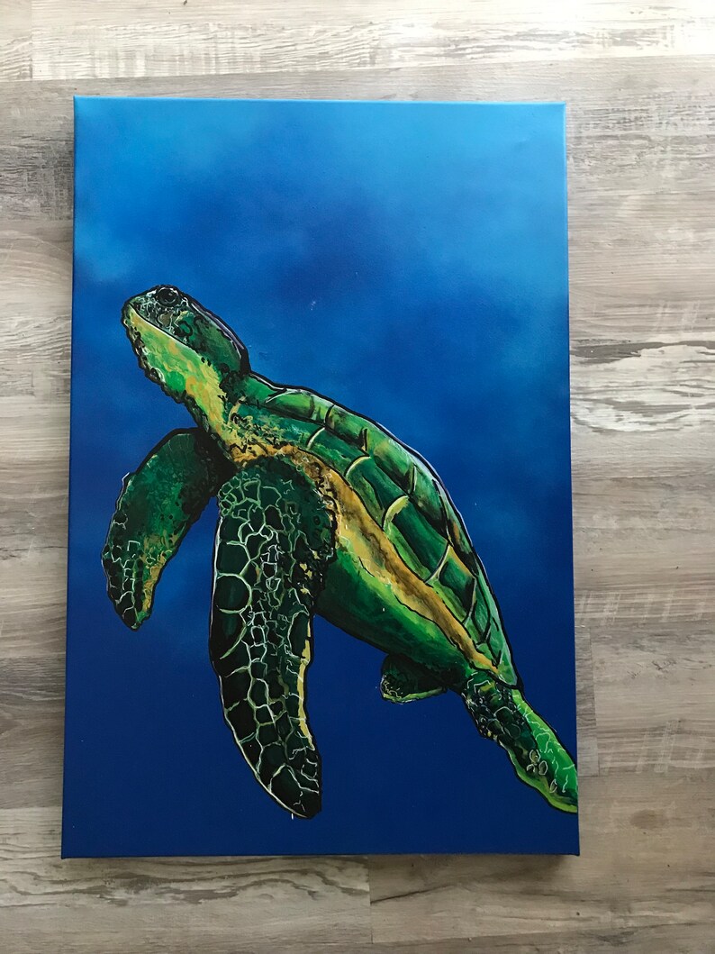May include: A green sea turtle swimming in a blue ocean. The turtle has a green shell with yellow markings and is swimming with its head and flippers above the water.