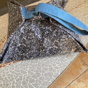 May include: A black and white patterned tote bag with a blue denim strap.