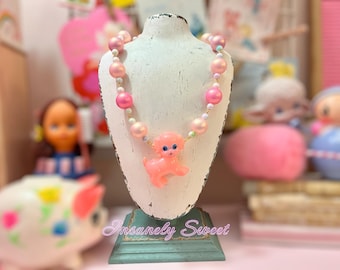 Collar de perlas con forma de perro de plástico rosa de juguete vintage kitsch