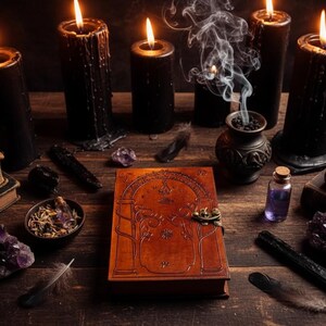 Puede incluir: Una naturaleza muerta m&iacute;stica con velas negras encendidas, un libro encuadernado en cuero, cristales, plumas y una olla humeante. La escena est&aacute; ambientada sobre una superficie de madera oscura, creando un ambiente misterioso.