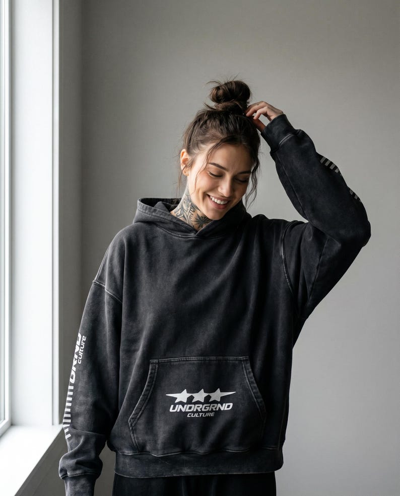 May include: Black hoodie with a front pocket and the text "UNDRGRND CULTURE" with three stars. The sleeves have the text "UNDRGRND culture" printed vertically. The hoodie is a dark gray color.
