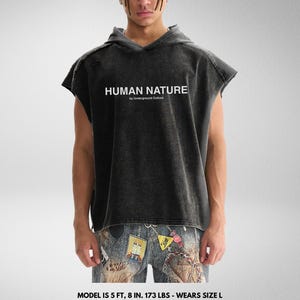 May include: A black sleeveless hoodie with a distressed look. The hoodie has a white print that says "HUMAN NATURE by Underground Culture".