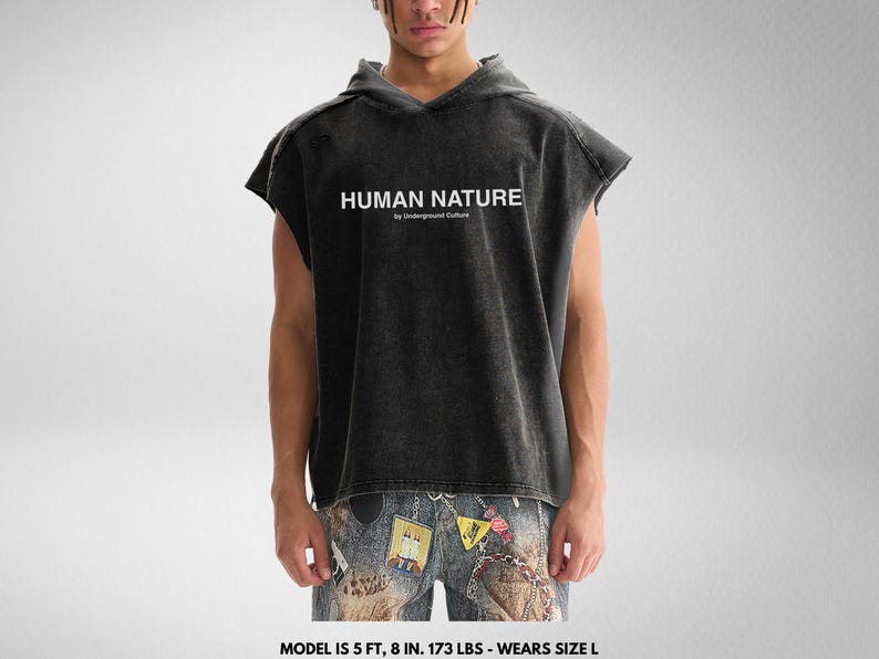 May include: A black sleeveless hoodie with a distressed look. The hoodie has a white print that says "HUMAN NATURE by Underground Culture".