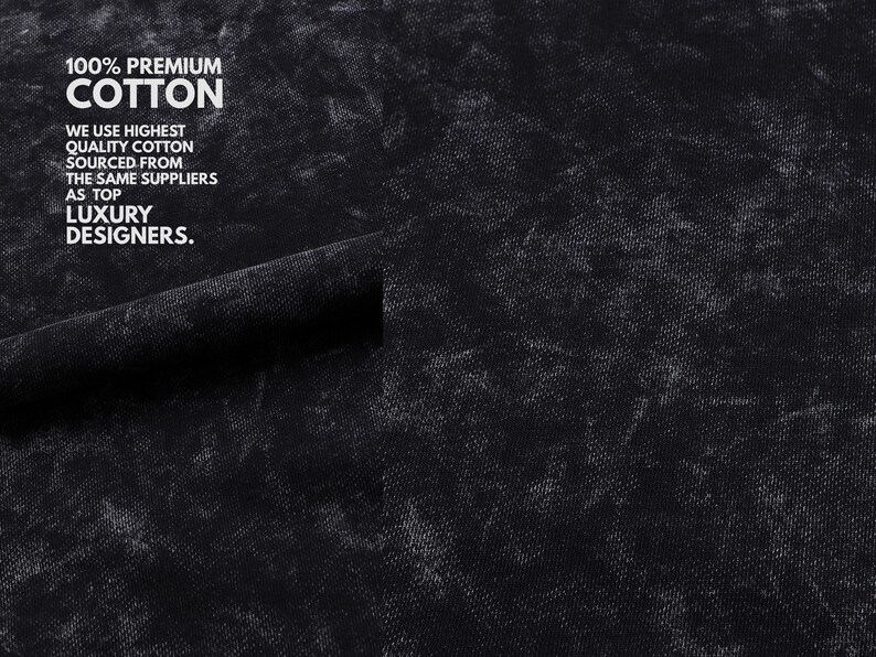 May include: Close-up of black fabric with a textured, mottled appearance. White text reads "100% PREMIUM COTTON" and additional text stating the cotton is sourced from the same suppliers as luxury designers.