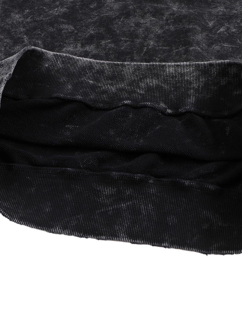 May include: Close-up of a black sweatshirt with a distressed, textured appearance. The ribbed neckline and hem are visible, with a faded, worn look. The fabric appears to be a heavy knit, suitable for cooler weather.