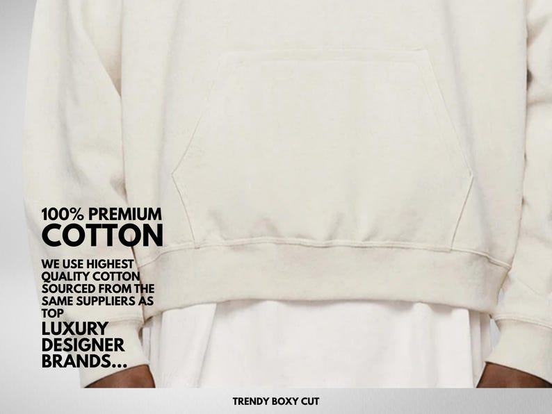Pu&ograve; includere: Felpa con cappuccio color crema con tasca frontale e la scritta "100% PREMIUM COTTON". La felpa &egrave; realizzata in un materiale morbido e ha un taglio squadrato alla moda. Il testo menziona anche l'uso di cotone di alta qualit&agrave;.