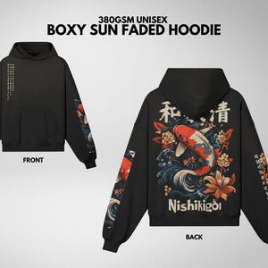 Pu&ograve; includere: Felpa con cappuccio unisex nera boxy sun faded con tasca frontale e cappuccio. La parte posteriore presenta un design di carpa koi con testo giapponese e la parola "Nishikigoi". Le maniche hanno dettagli floreali e testuali.