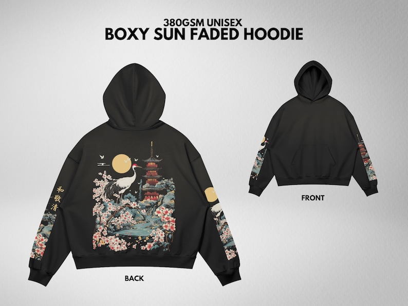 May include: Black boxy hoodie with a Japanese-inspired design. The back features a crane, pagoda, and floral elements. Sleeves have matching artwork. The front view shows a plain black hoodie. Text on the hoodie reads "380GSM UNISEX BOXY SUN FADED HOODIE".