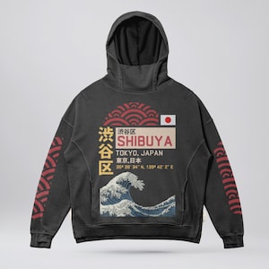 May include: Black hooded sweatshirt with a graphic print of a Japanese wave and the text "渋谷区 SHIBUYA TOKYO, JAPAN 東京,日本 35° 39' 34" N, 139° 42' 2" E" in red and white.