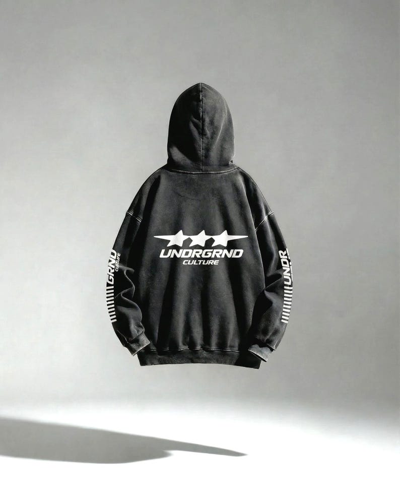 May include: A black hoodie with the text "UNDRGRND CULTURE" in white, along with three white stars. The sleeves have vertical white text and lines. The hoodie has a vintage, worn look.