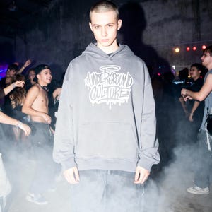 May include: A charcoal gray hooded sweatshirt featuring a front kangaroo pocket and a white graphic print on the chest that reads "UNDERGROUND CULTURE" in a stylized graffiti font with a halo above the text and dripping paint effects.