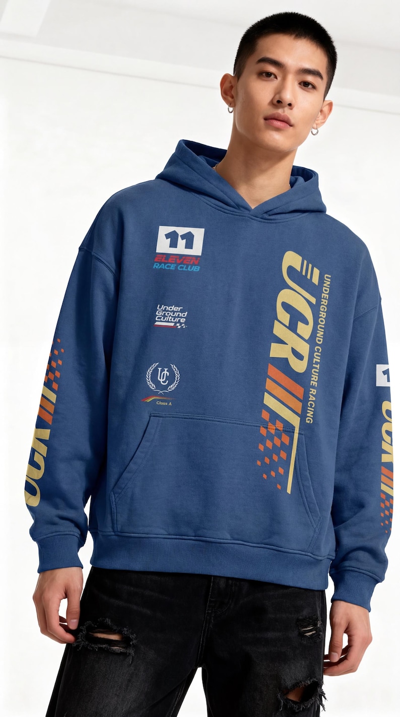 May include: Blue hoodie with "UCR" and "Underground Culture Racing" graphics in gold and orange. Features a front pocket and the number "11" on the chest. The sleeves have additional graphics. A casual streetwear style.