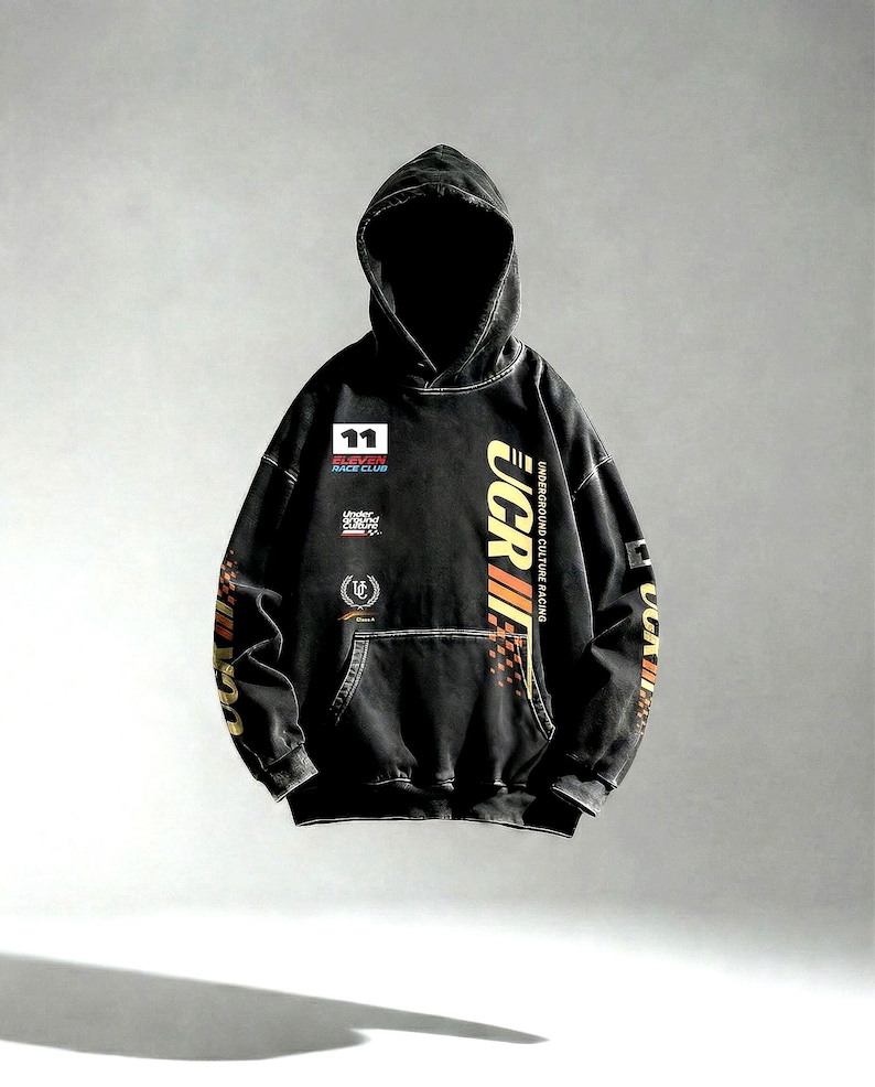 May include: Black hooded sweatshirt with multiple patches and text. The front features a patch with the number 11 and the words "RACE CLUB". The right sleeve has the text "UCR" in yellow and orange. The sweatshirt has a kangaroo pocket.