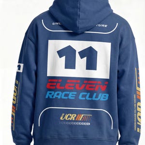 May include: A navy blue hooded sweatshirt with the number "11" in white on the back. The sweatshirt features the text "ELEVEN RACE CLUB" in red and blue, and other graphics. The sleeves have text and graphics in yellow and white.