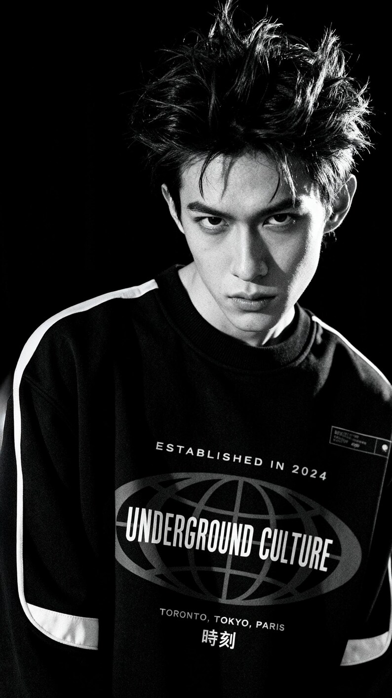 May include: A black long-sleeve sweatshirt with white side stripes and a graphic print featuring the text ESTABLISHED IN 2024, UNDERGROUND CULTURE, TORONTO, TOKYO, PARIS, and the Japanese characters 時刻 centred within an oval globe design.
