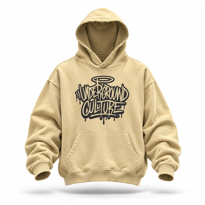 May include: A tan hooded sweatshirt featuring a front kangaroo pocket and long sleeves with ribbed cuffs. The chest displays a black graphic design with the text Underground Culture in a stylized graffiti font, complete with a halo above the lettering.