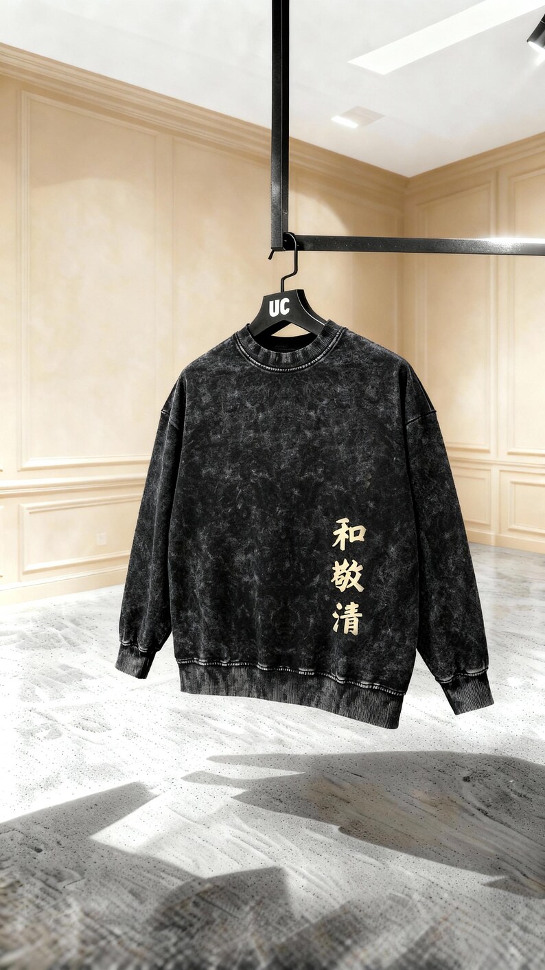 May include: Black acid wash sweatshirt with the text "和敬清" in gold lettering. The sweatshirt has a crew neck and long sleeves. The hanger has "UC" printed on it.