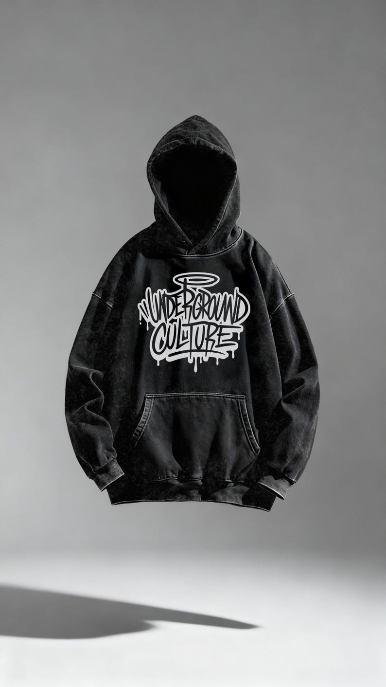 May include: A black hooded sweatshirt with a washed-out, faded texture. The front features a large white graphic with the text "UNDERGROUND CULTURE" in a stylized graffiti font, complete with a halo icon above the lettering and drip effects.