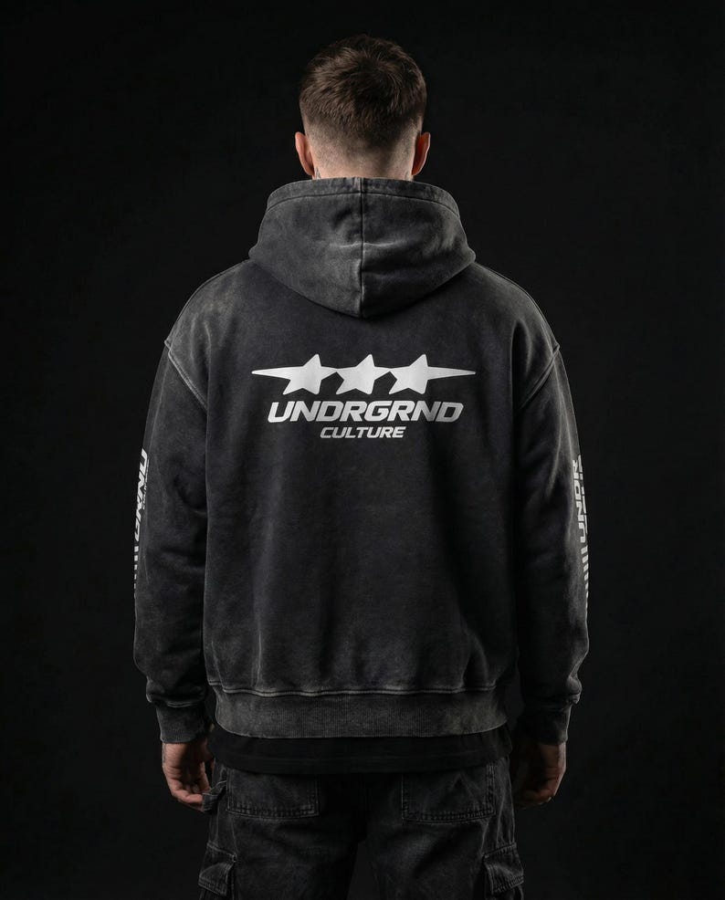May include: A dark gray hoodie with a faded, vintage look. The back features the text "UNDRGRND CULTURE" in white, with three star graphics above the text. The sleeves also have white text. The hoodie has a drawstring hood.