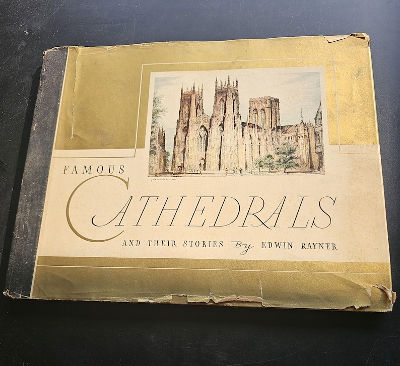 Op de afbeelding: Een vintage boek getiteld "Famous Cathedrals and Their Stories" door Edwin Rayner. De omslag toont een aquarel illustratie van een kathedraal met beige en gouden accenten. De kaft van het boek is licht versleten.