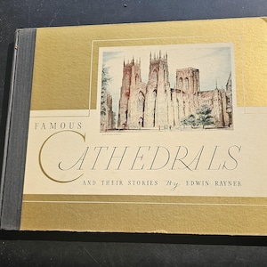 Op de afbeelding: Een vintage boek getiteld "Famous Cathedrals and Their Stories" door Edwin Rayner. De omslag is goud en cr&egrave;me, met een illustratie van een kathedraal. De rug van het boek is donkergrijs.
