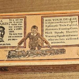 May include: Vintage Lionel Trains box with illustrations and text. The box features a drawing of a man and a train, with text that reads "ALL ABOARD!" and "ASK YOUR DEALER". The box is tan and orange.