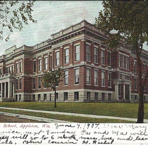 Może przedstawiać: Stara pocztówka przedstawiająca Appleton High School w Appleton, Wisconsin. Pocztówka jest datowana na 4 czerwca 1907 roku i zawiera ręcznie napisany komunikat.