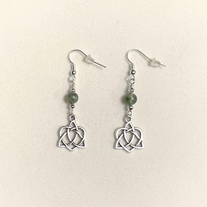 May include: Silver Celtic knot earrings with green stone beads. The knots are in the shape of a heart.