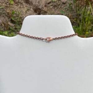 Op de afbeelding: Een koperen ketting met een karabijn sluiting.