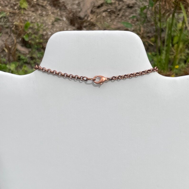 Op de afbeelding: Een koperen ketting met een karabijn sluiting.