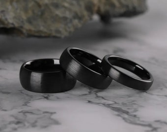 Sembra che tu stia descrivendo l'anello nero spazzolato in ceramica Tigrade, disponibile in una varietà di larghezze (4 mm, 6 mm, 8 mm) per adattarsi a entrambi.