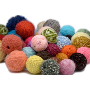 Può includere: Una collezione di gomitoli colorati di varie dimensioni e trame. I gomitoli sono nelle tonalità di rosa, arancione, giallo, blu, verde e marrone. Alcuni gomitoli hanno una consistenza soffice, altri sono lisci.