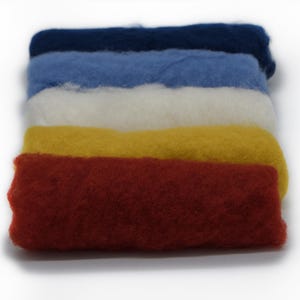 May include: A stack of colorful wool roving in shades of navy blue, light blue, white, yellow, and red. The wool is soft and fluffy, ideal for various fiber art projects like felting and spinning.
