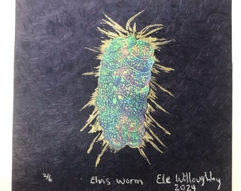 May include: A black and gold print of a green and iridescent worm with the text "Elvis Worm" and "Ele Willoughby 2024" in white.