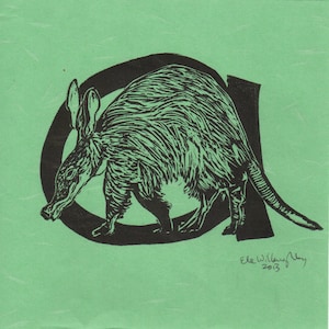 Peut inclure: Une estampe linogravure en noir et blanc d'un oryctérope debout dans la lettre "A". L'estampe est sur un fond vert et signée "Ele Willoughby 2013".